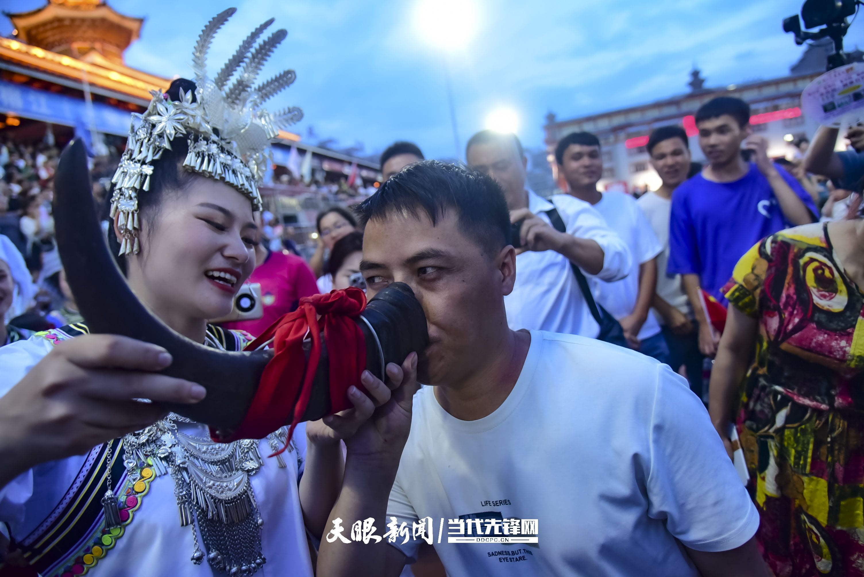 村超現(xiàn)場(chǎng)，當(dāng)?shù)厝罕娤蜻h(yuǎn)道而來(lái)的游客敬酒。 潘邵平 攝.jpg
